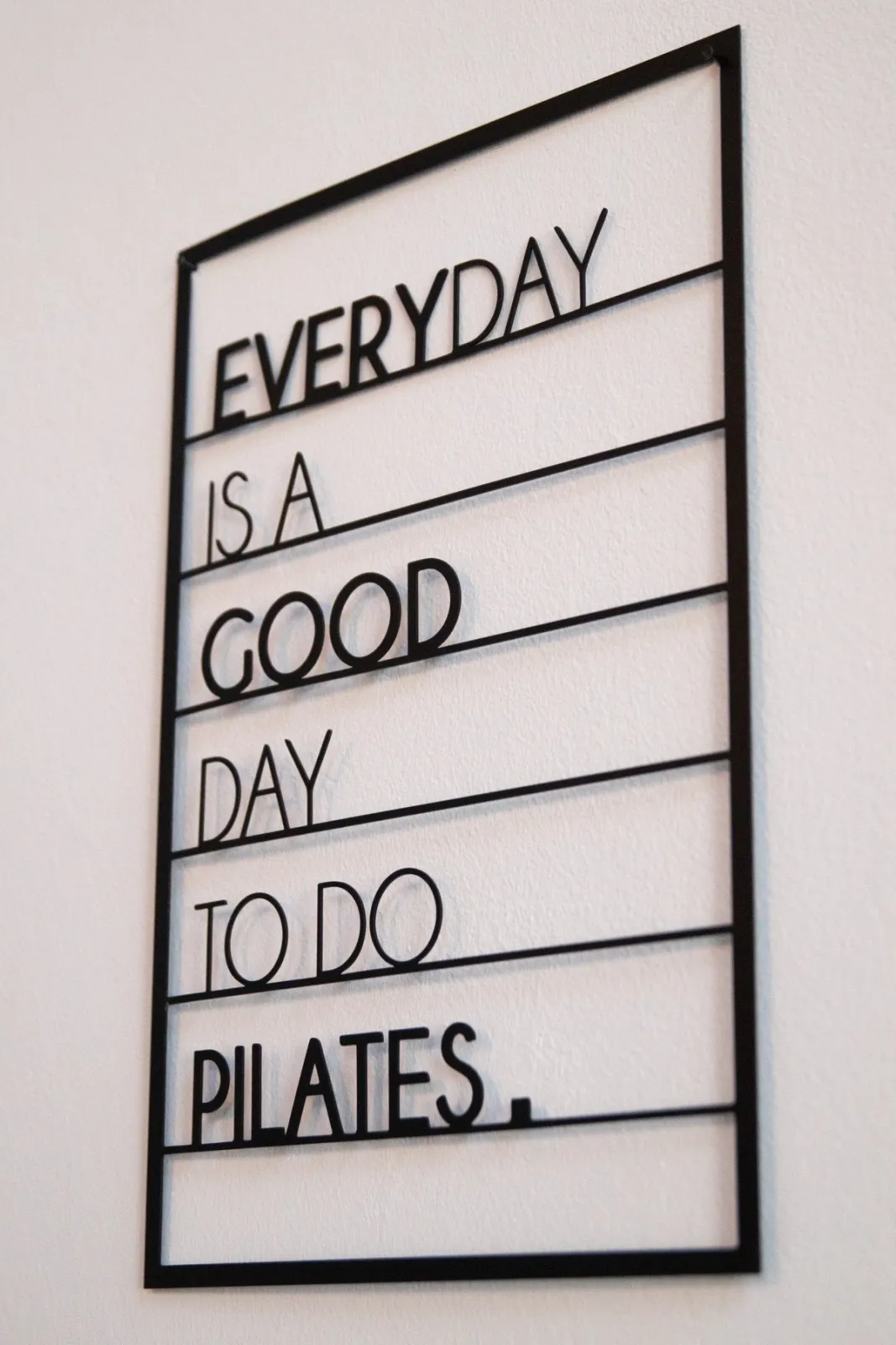 Scritta a parete: Everyday is a good day to do Pilates, fotografata di scorcio nello studio.